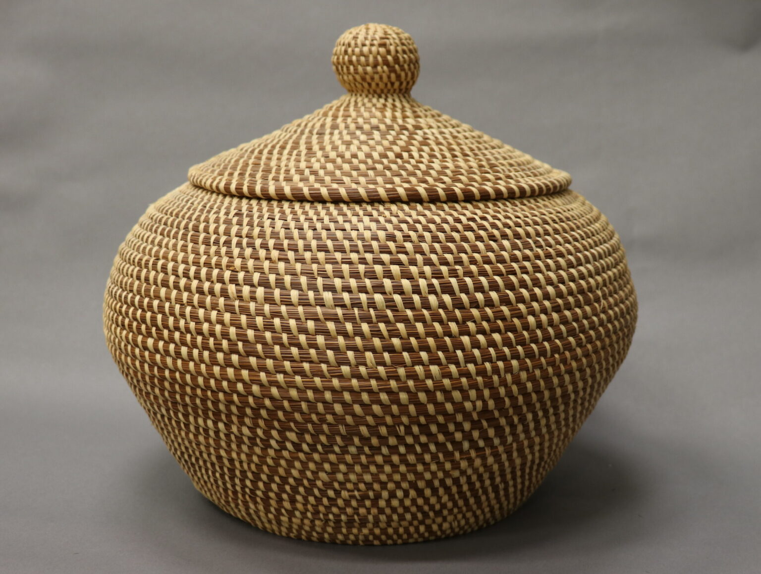 Darlene Langley Robinson. Coiled and sewn storage basket with lid, 2000. Longleaf pine (Pinus palustris) needles, coyyihissí, rafﬁa, pahí.